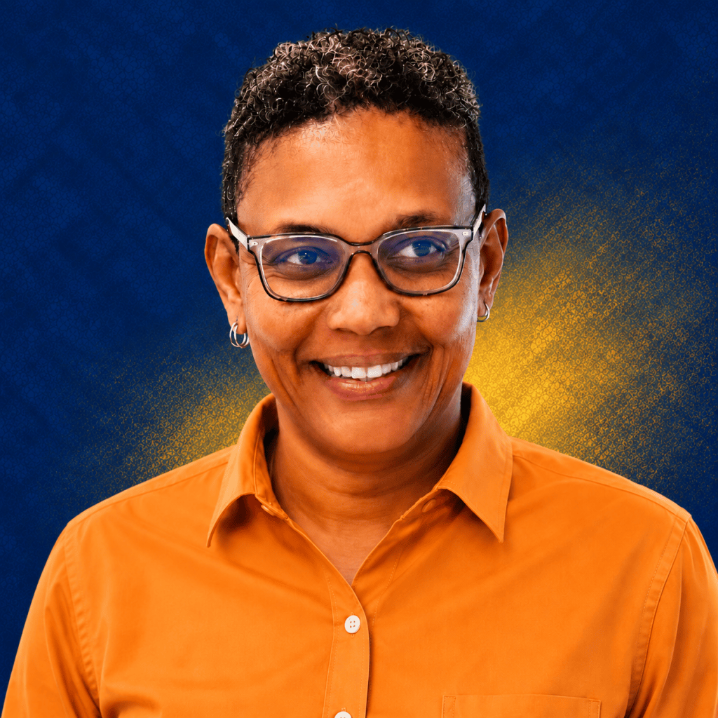 Giselle Hudson, The Pre-Fixer, smiling in an orange shirt against a navy background