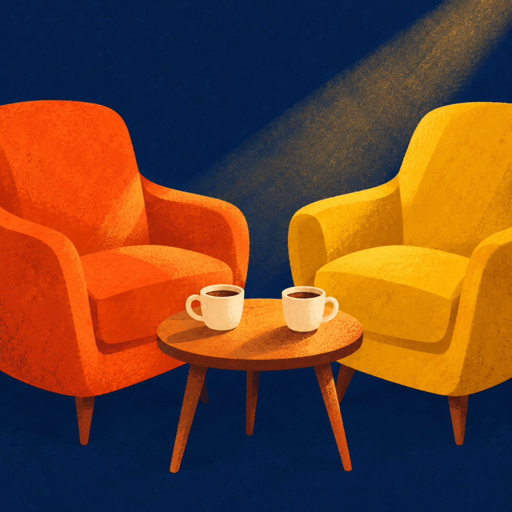 Two armchairs facing each other with coffee cups between them, lit by warm golden light